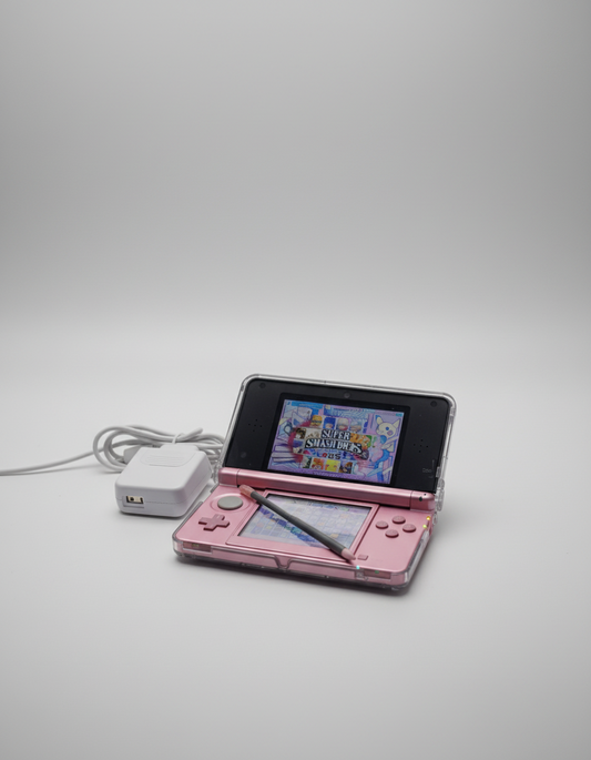 Pink handheld gaming device with screen displaying 'Super Smash Bros.' game on a glittery gold surface. 3DS Modded 3DS Custom Firmware Red Nintendo 3DS with a game displayed on a desk with computer equipment. Handheld 128gb 256gb custom firmware emulators anemone h shop modded 3ds 3dsxl new2dsxl 2ds N3DSXL new gaming retro handheld
