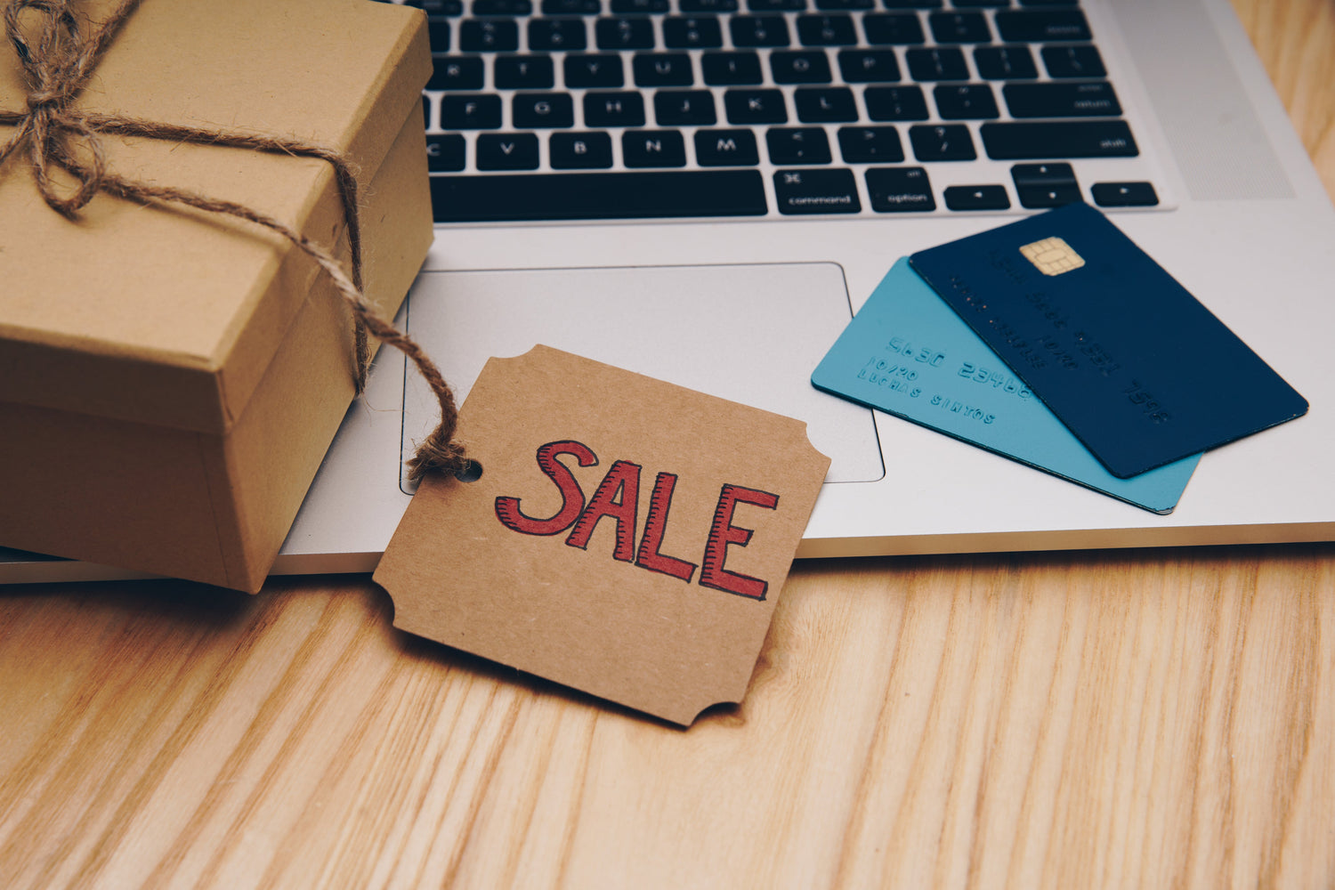 “Colorful retro gaming handhelds and accessories displayed around gift boxes, with icons for payment options and a “Sale” badge.”  “Vintage handheld consoles surrounded by wrapped presents, credit card and PayPal logos, and a red sale tag.”