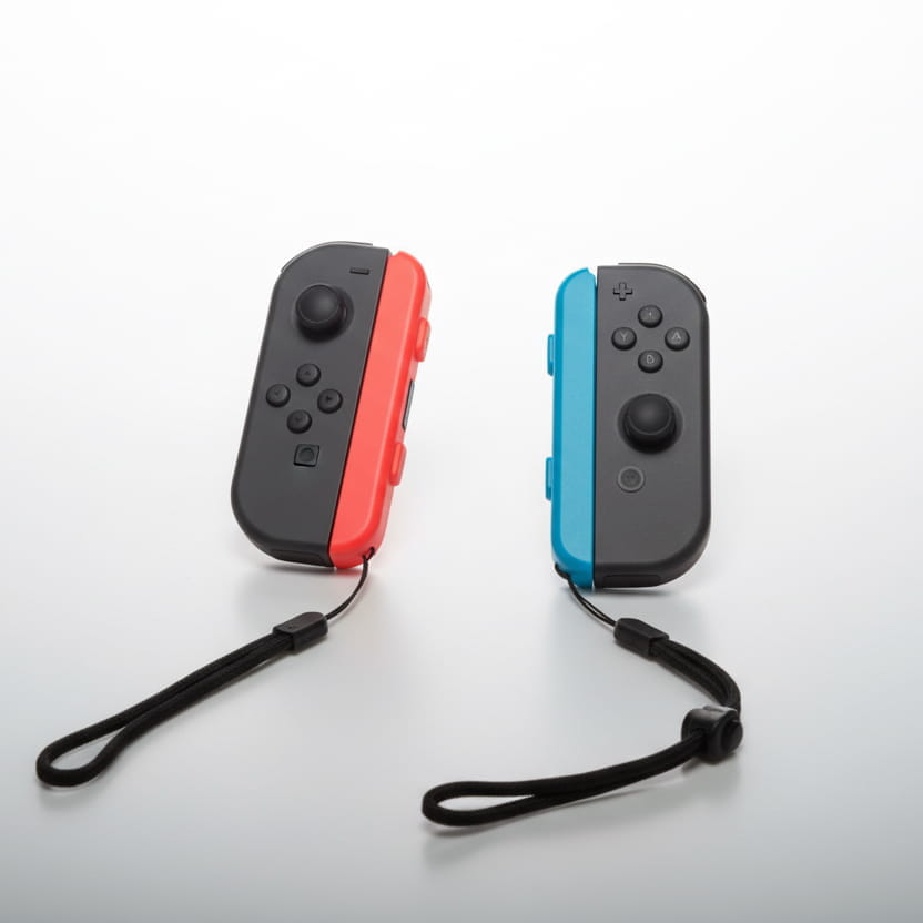 Black Nintendo Switch Joy-Con controllers with neon red blue grip attachments modded console
