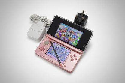 Pink handheld gaming device with screen displaying colorful graphics on a carpeted floor.Pink handheld gaming device with screen displaying 'Super Smash Bros.' game on a glittery gold surface. 3DS Modded 3DS Custom Red Nintendo 3DS with a game displayed on a desk with computer equipment. Handheld 128gb 256gb custom firmware emulators anemone h shop modded 3ds 3dsxl new2dsxl 2ds N3DSXL new gaming retro handheld  Firmware