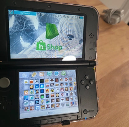 Nintendo DS device showing two screens with game icons and a web browser. Modified Nintendo 3DS XL with custom firmware, Luma3DS, homebrew apps, emulators, customizable themes, and enhanced performance features.