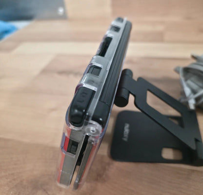 Phone case on a wooden surface with a blurred background Modified Nintendo 3DS XL with custom firmware, Luma3DS, homebrew apps, emulators, customizable themes, and enhanced performance features.