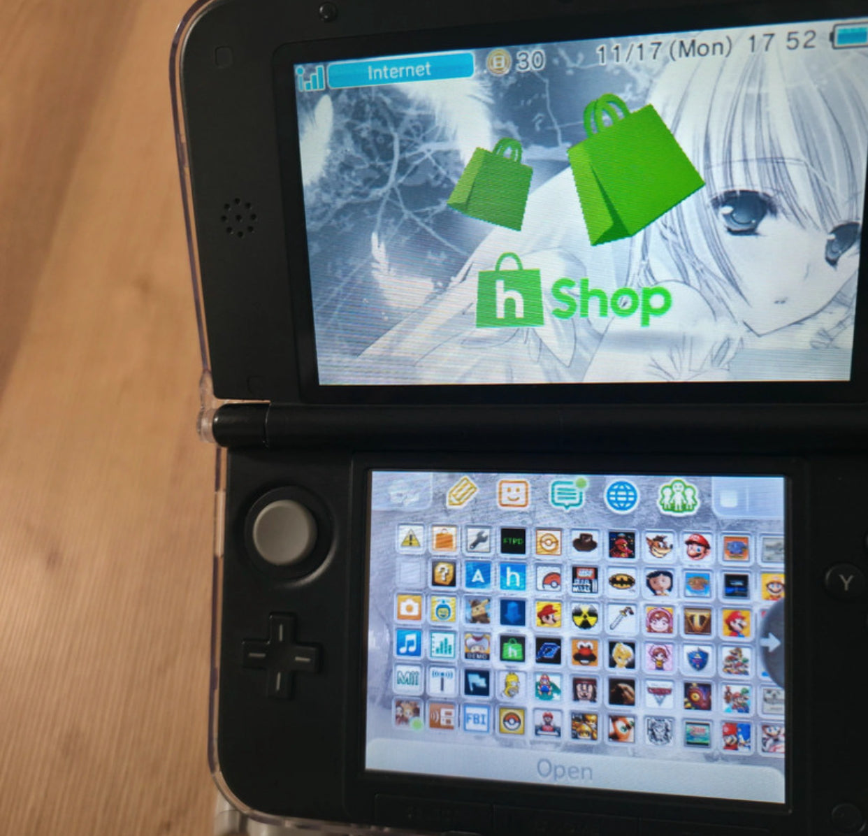 Nintendo 3DS displaying a shopping app interface on the screen Modified Nintendo 3DS XL with custom firmware, Luma3DS, homebrew apps, emulators, customizable themes, and enhanced performance features.