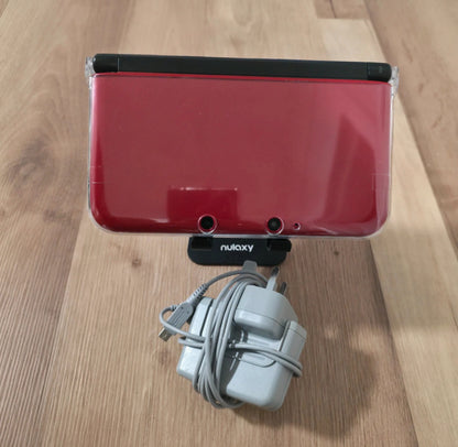 Red electronic device with a cable on a wooden surface Modified Nintendo 3DS XL with custom firmware, Luma3DS, homebrew apps, emulators, customizable themes, and enhanced performance features.