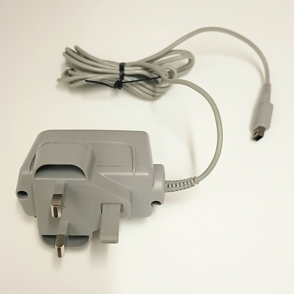 Gray power adapter with UK plug and cable on a white background Modded New Nintendo 2DS XL with Luma custom firmware, 128GB SD card, emulators, homebrew apps, and pre-installed software, displayed in excellent condition for retro and 3DS gaming.