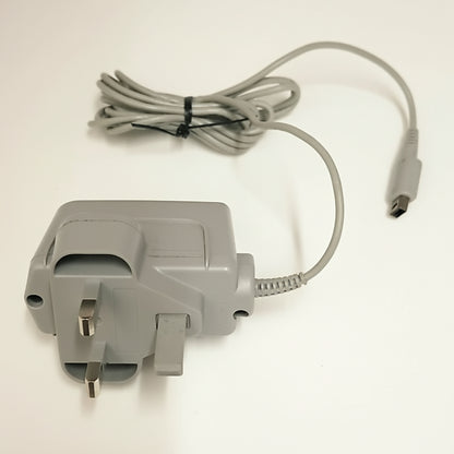 Gray power adapter with UK plug and cable on a white background Modded New Nintendo 2DS XL with Luma custom firmware, 128GB SD card, emulators, homebrew apps, and pre-installed software, displayed in excellent condition for retro and 3DS gaming.