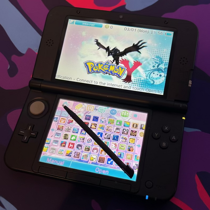 Modded Nintendo 3DS XL black playing anime game with custom firmware and neon purple lighting
