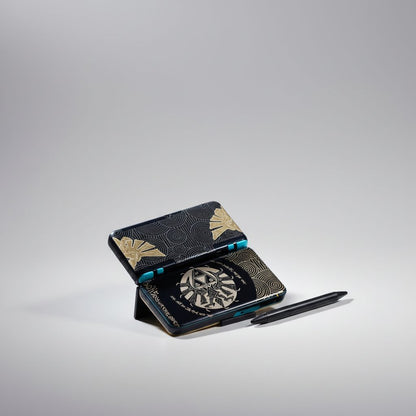 Ember Glow New 2DS XL shell with gold mandala artwork and teal accents, displayed open on grey