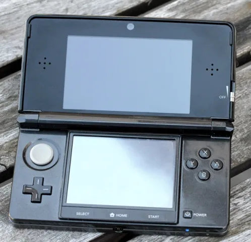 Video showing a modded Nintendo 3DS with 128GB storage running custom firmware, featuring a custom theme interface, Homebrew menu, and various installed emulator apps. Clear plastic case with branding on a blue and wooden surfacePink handheld gaming device with screen displaying 'Super Smash Bros.' game on a glittery gold surface. 3DS Modded 3DS Custom Firmware 128gb emulators, anemone, h shop, homebrew
